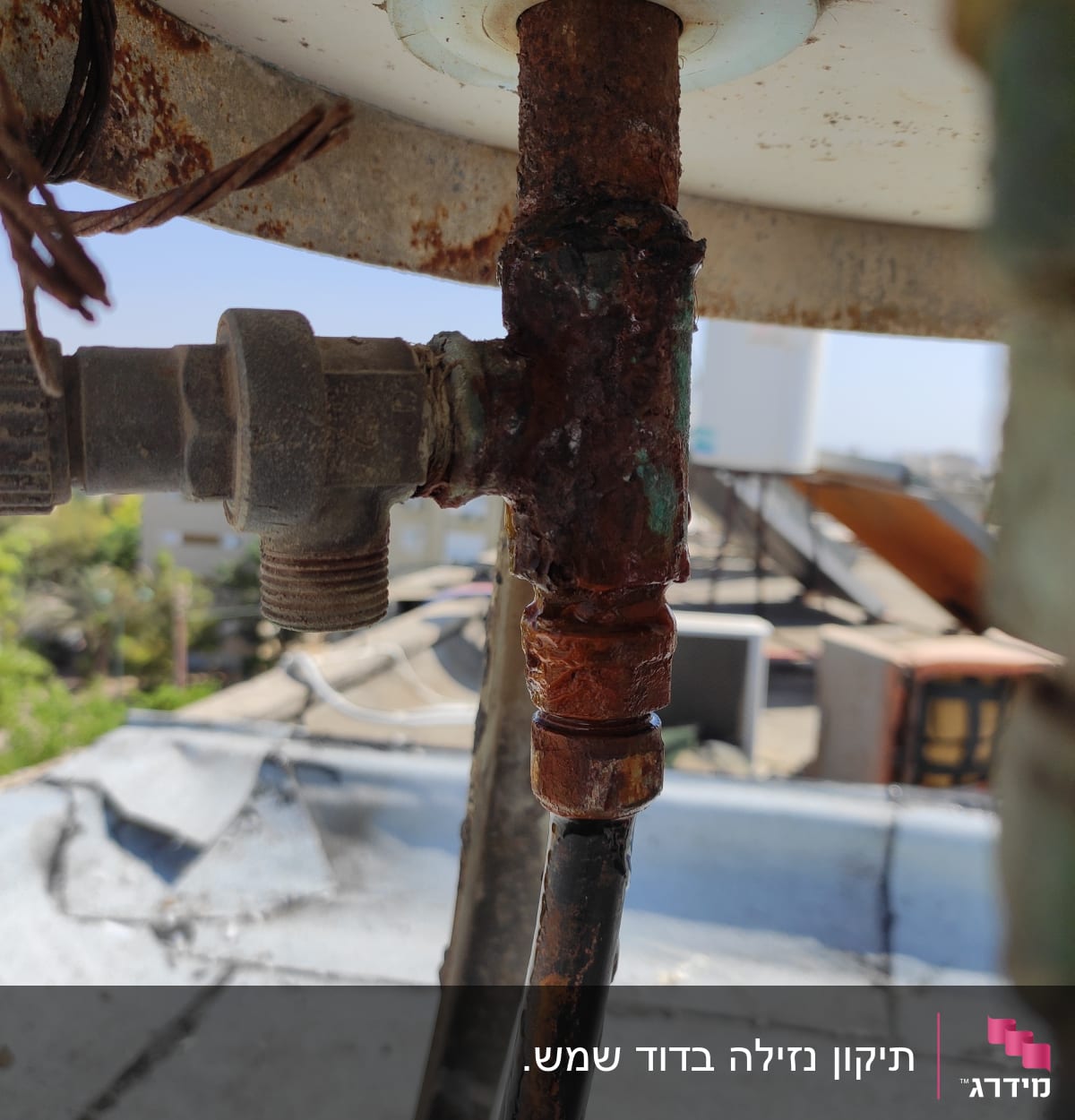 צינור חלוד מחובר לדוד שמש על גג